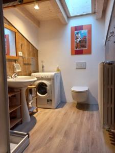 a bathroom with a washing machine and a sink at Chalet Relax in Pozza di Fassa