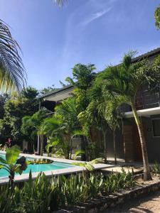 una piscina di fronte a una casa con palme di Veleta Inn a Tulum