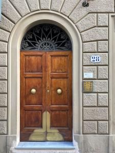 une porte en bois dans un mur en pierre avec un panneau au-dessus. dans l'établissement Santa Reparata downtown, à Florence