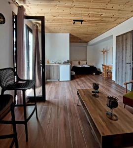 Agros Green Valley Suites في ليماسول: غرفة معيشة مع طاولة وغرفة مع سرير