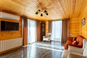 sala de estar con sofá y TV de pantalla plana en Eco house villa jeo, en Tiflis