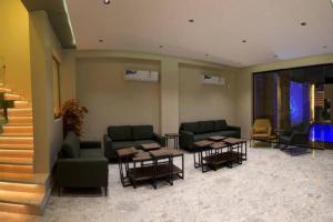 una hall con divani, tavoli e una scala di The Palms Resort (3) a Riyad