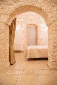 una camera con un letto in una parete in pietra di I trulli di Nonno Battista a Locorotondo