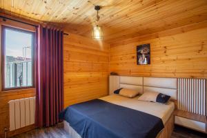 a bedroom with a bed in a wooden cabin at Eco house villa jeo in Tbilisi City
