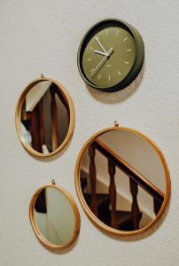 three mirrors and a clock on a wall at Mayen, Bäckerstr, Privatzimmer Nr4, Innenstadt, nähe Nürburgring & Burg Eltz, Gemeinschaftsbad in Mayen