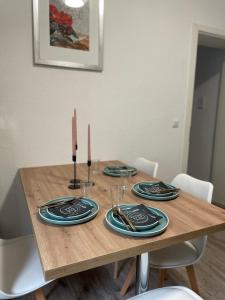 a wooden table with plates and utensils on it at Mayen, Bäckerstr, Privatzimmer Nr4, Innenstadt, nähe Nürburgring & Burg Eltz, Gemeinschaftsbad in Mayen