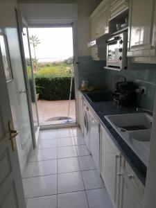 a kitchen with a door open to a patio at Antibes T2 Vue mer 48m2 Terrasse Parking Piscine Plage in Antibes