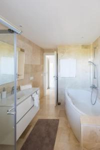 a bathroom with a tub and a sink and a bath tub at Luxusvilla Casaabel in Roca Llisa
