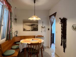 uma sala de jantar com uma mesa e cadeiras e um lustre em Apartman Blaga em Povlja