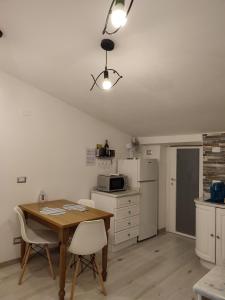 a kitchen with a table and a refrigerator and a microwave at Passione Mare in Portovenere