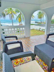 a room with chairs and a view of the beach at Puesta del Sol Guest House in San Andrés