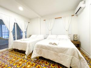 聖安德烈斯的住宿－Puesta del Sol Guest House，一间卧室设有两张床和窗户。