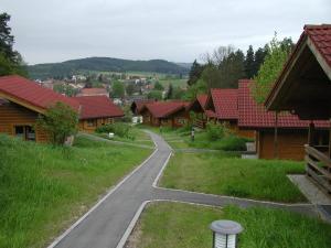 une route sinueuse traversant un village avec des maisons en bois dans l'établissement Ferienhaus Chalet Blockhaus Bayern, à Stamsried