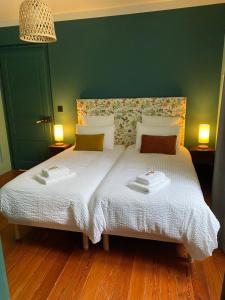 a bedroom with a bed with two towels on it at LE CLOS DU TULIPIER in La Chapelle-du-Bard