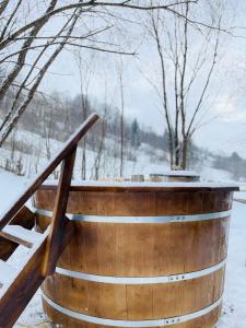 a wooden barrel with snow on top of it at Tiny Apartment in Apuseni Mountains 