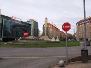 una señal de stop en la esquina de una calle con edificios en Apartamento Los Fresnos, en Gijón