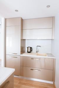 a kitchen with white cabinets and a sink at New Exclusive 2 Bedroom Apartment in OldRiga in Rīga