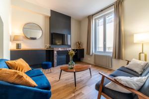 - un salon avec un canapé bleu et une table dans l'établissement L'Orée du Faubourg - VENDOME CENTRE, à Vendôme