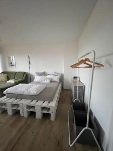 um quarto branco com uma cama e um sofá em Apartment mit schönem Ausblick em Lüdenscheid