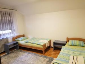 a room with two beds and a window and two tables at Visoko Homestay in Visoko