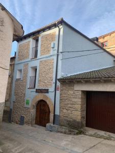 ein altes Steingebäude mit einer Tür und einer Garage in der Unterkunft Apartamento Rural Casa Bergua en Arguis in Arguis