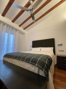 a bedroom with a bed with a ceiling fan at Piso en el centro de Alcoy para sentirte en casa in Alcoy