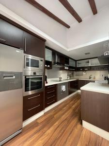 a large kitchen with stainless steel appliances and wooden floors at Piso en el centro de Alcoy para sentirte en casa in Alcoy
