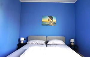 um quarto com uma cama e uma parede azul em IL FIOCCO em Marina di Ravenna