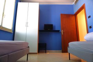 um quarto com paredes azuis, uma porta e uma cama em IL FIOCCO em Marina di Ravenna