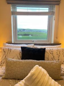 a couch with pillows in front of a window at Normsy Place Seaside Serenity Breath Taking Views in St Bees