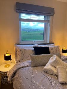 a bedroom with a bed with a window at Normsy Place Seaside Serenity Breath Taking Views in St Bees