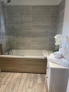 a bathroom with a bath tub and a sink at Normsy Place Seaside Serenity Breath Taking Views in St Bees