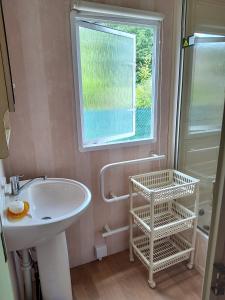 ein Bad mit einem Waschbecken und einem Fenster in der Unterkunft Wakacje nad morzem w Rusinowie in Rusinowo