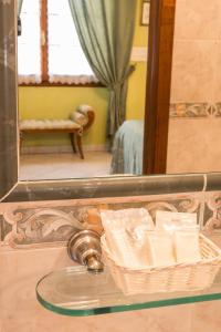 un espejo con una cesta de toallas en una mesa de cristal en B&B Old Florence Inn, en Florencia