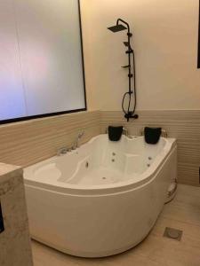 y baño con bañera blanca grande. en The Palms Resort (2) en Riad