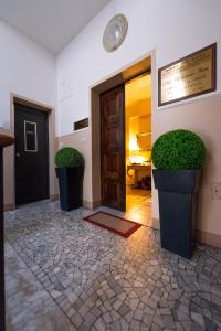 a hallway with a door and two potted plants at B&B Old Florence Inn in Florence