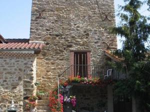 a stone building with a balcony with flowers on it at Gîte Lorlanges, 3 pièces, 8 personnes - FR-1-582-352 in Lorlanges