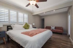 a bedroom with a large bed with a ceiling fan at The Pink Cactus - Desert Retreat - Luxe Pool, Golf & Game Room in Indio +32 photos