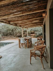 un patio con sillas, una mesa y una mesa con sillas en UmnDeni Africa, en Hoedspruit