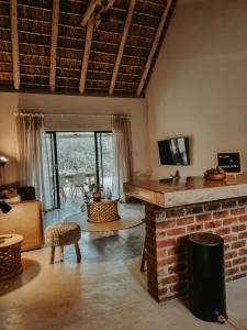 a living room with a brick fireplace and a couch at UmnDeni Africa in Hoedspruit