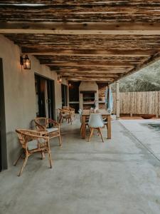 un patio con sillas, mesas y techo de madera. en UmnDeni Africa, en Hoedspruit
