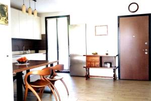 eine Küche mit einem Tisch und Stühlen sowie einem Kühlschrank in der Unterkunft Appartamento moderno in posizione strategica in Sala Baganza