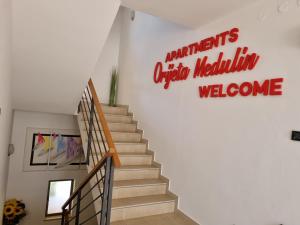 a staircase with a sign that reads nationals origin melusalem welcome at Apartments Medulin - Orijeta in Medulin