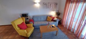 a living room with a blue couch and yellow chairs at Marina Park Garden in Lagos in Lagos