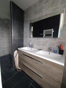 La salle de bains est pourvue d'une baignoire, d'un lavabo et d'un miroir. dans l'établissement Face Nausicaa et plage vue panoramique, à Boulogne-sur-Mer