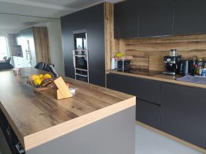 a kitchen with a wooden counter top with a bowl of fruit at Face Nausicaa et plage vue panoramique in Boulogne-sur-Mer