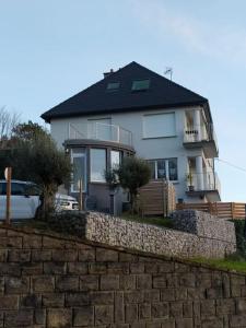 a white house behind a stone retaining wall at Face Nausicaa et plage vue panoramique in Boulogne-sur-Mer