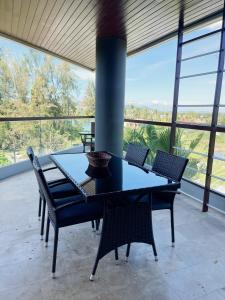 una mesa y sillas en una habitación con ventanas en The Regent Bangtao Apartments en Bang Tao Beach