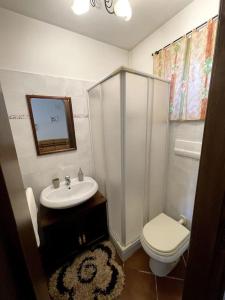 プティニャーノにあるTavernaの洗面台とトイレを備えた白いバスルーム
