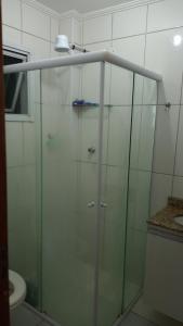 a glass shower in a bathroom with a sink at Apartamento Praia Grande Ocian in Praia Grande